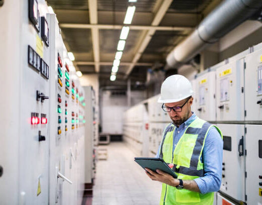 Electrical engineer working in control room. Electrical engineer checking Power Distribution Cabinet in the control room