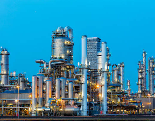 A large, modern petrochemical plant at dusk in industrial district near Rotterdam, Netherlands, Benelux, Europe. Distillation towers and other installations are visible against blue sky. 50 megapixel image taken with Canon EOS 5Ds, digital blending technique, long exposure with tripod.